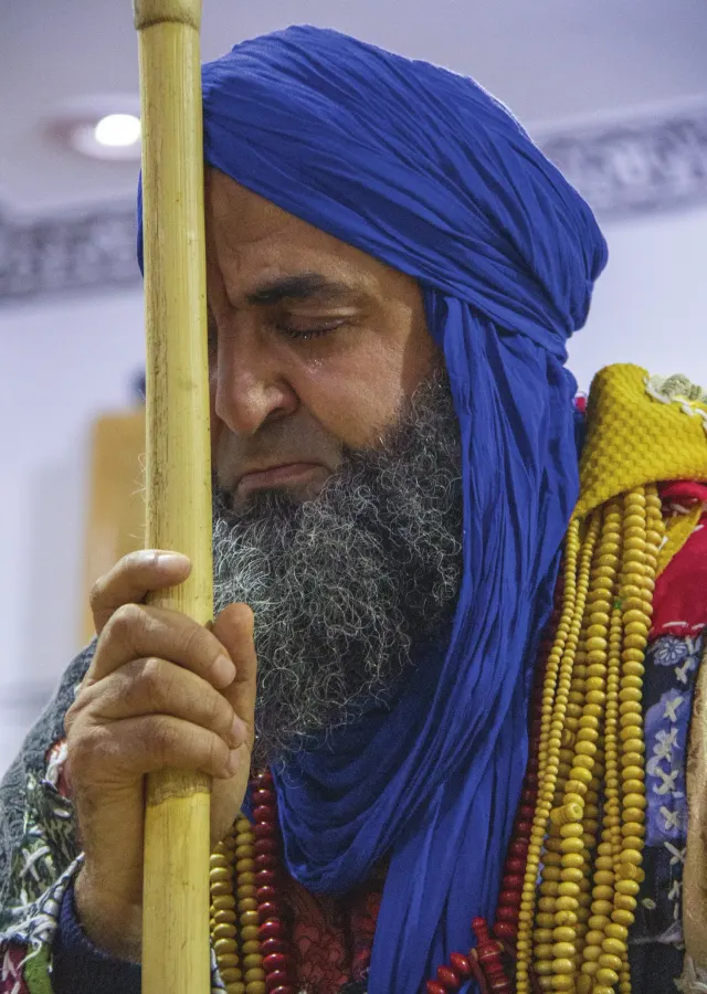Le Shaykh, turban bleu et bâton